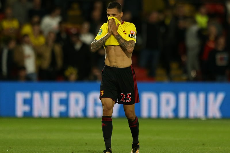 Jose Holebas walks off the pitch with his shirt in his face after being sent off.