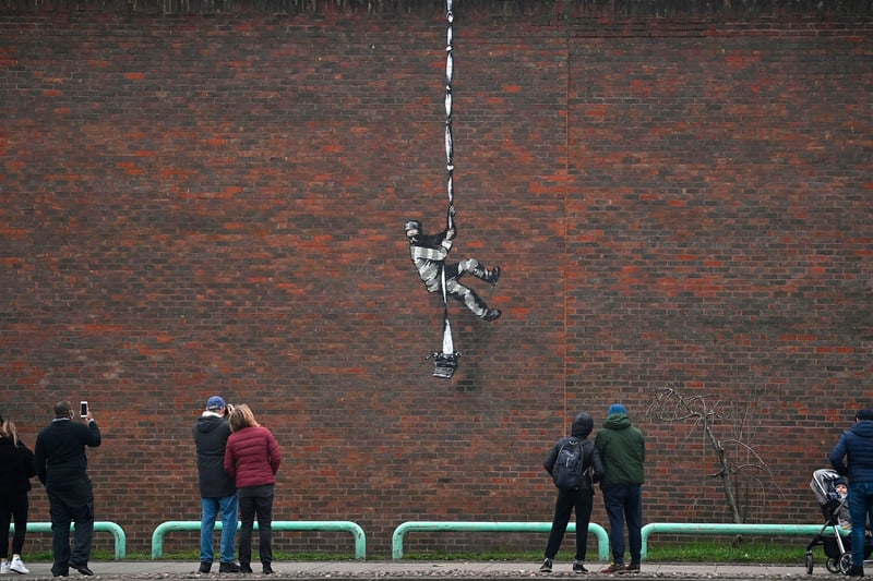 People gather round to witness artwork from Banksy
