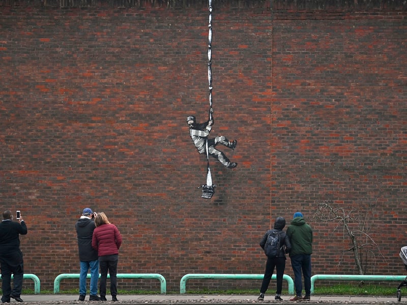 People gather round to witness artwork from Banksy