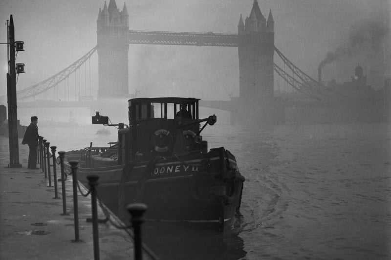 A tugboat on the Thames in heavy smog.