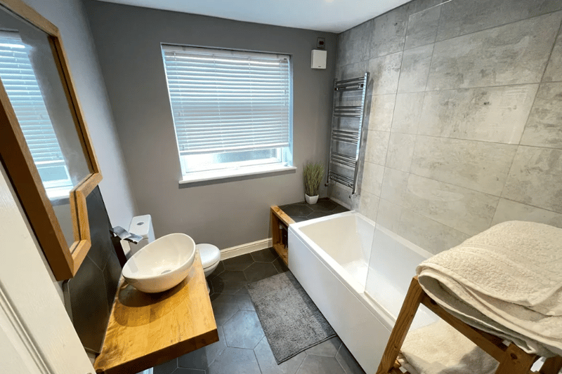 A cosy bathroom with big bath tub and more
