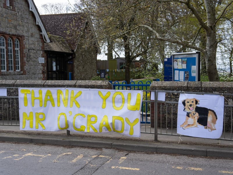 A banner is displayed outside a school for the funeral cortege of Paul O'Grady