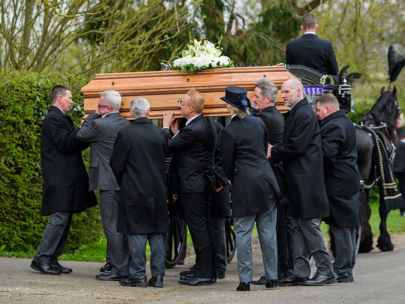 The coffin is carried into the church at the Funeral of Paul O'Grady