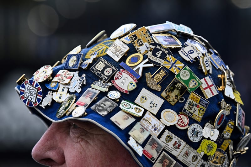 A Leeds’ fan wearing a hat covered in pins arrives at Elland Road