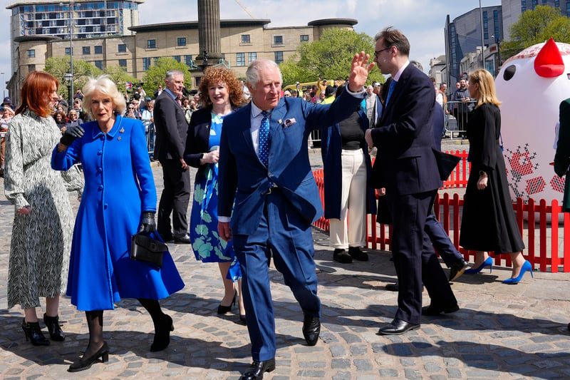 King Charles and the Queen Consort wave to fans in Liverpool.