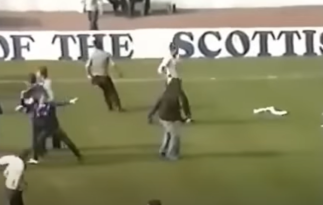 A fan on the pitch prepares to launch a bottle - around 100 people on both sides sustained serious injuries on the day while around 210 were arrested 210 - 160 of which happened within Hampden.