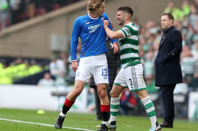 Celtic defender Greg Taylor grapples with Rangers attacker Todd Cantwell on the touchline as Michael Beale watches on.