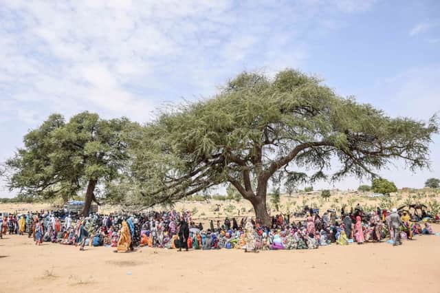 Sudanese refugees from the Tandelti area who crossed into Chad, in Koufroun, near Echbara, gather for aid distribution on April 30, 2023. (Photo by GUEIPEUR DENIS SASSOU/AFP via Getty Images)