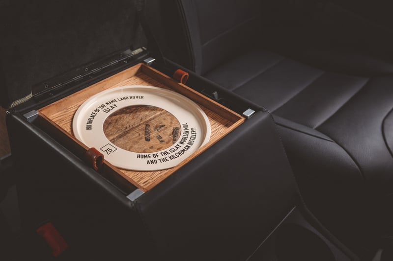The central stowage space features a bespoke removable tray made from the oak of whisky barrels sourced from the local Kilchoman distillery. Each tray features a unique wooden disc replicating the end of a whisky barrel and is made from a specific piece of the wood that displays the authentic stencilled lettering, meaning every vehicle is a one of a kind. 