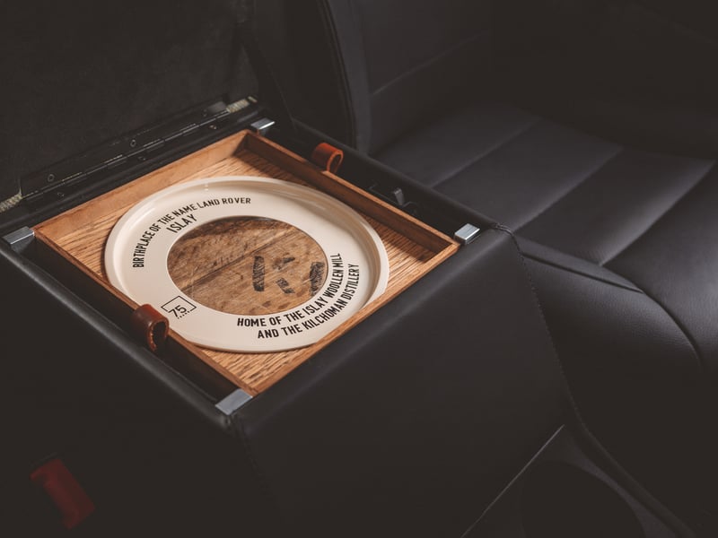 The central stowage space features a bespoke removable tray made from the oak of whisky barrels sourced from the local Kilchoman distillery. Each tray features a unique wooden disc replicating the end of a whisky barrel and is made from a specific piece of the wood that displays the authentic stencilled lettering, meaning every vehicle is a one of a kind. 