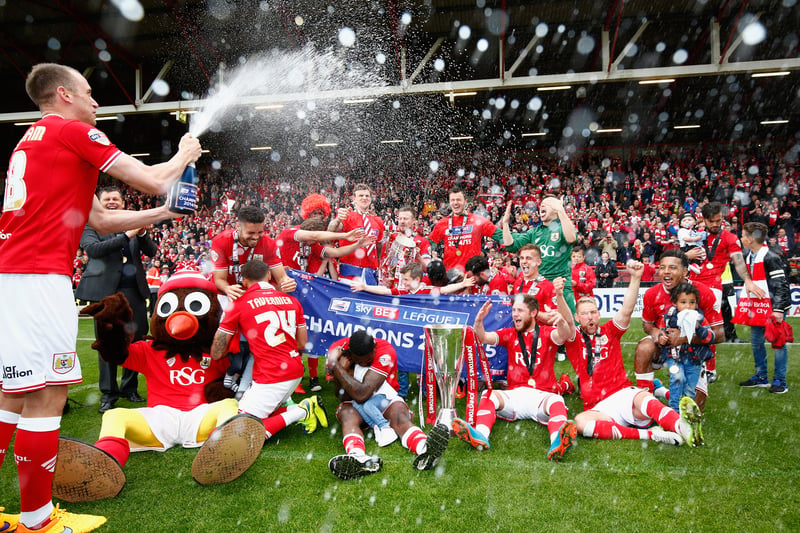 Top scorer Aaron Wilbraham puts champagne on Scrumpy the Robin and his teammates. 