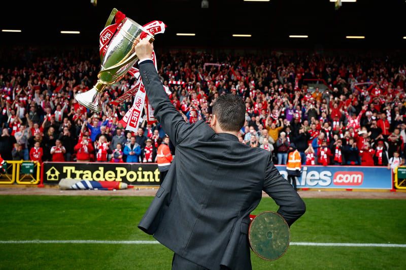 Steve Cotterill lifts the trophies in front of the supporters. 
