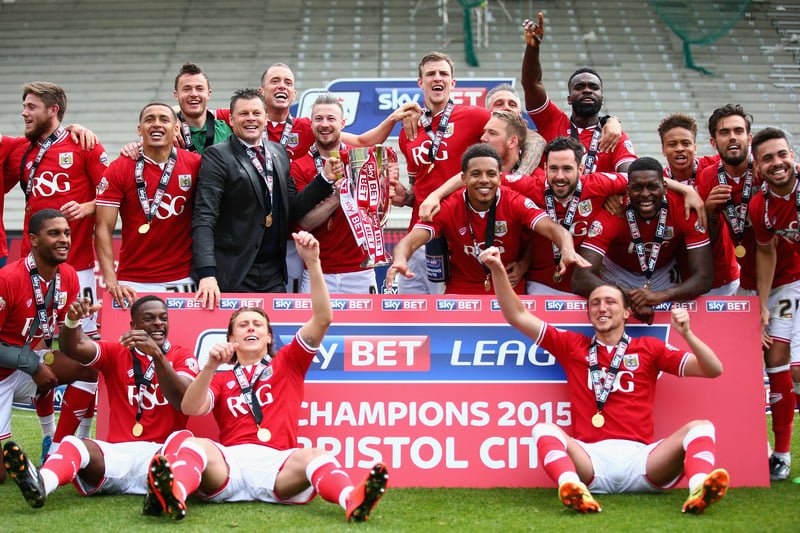 Bristol City’s squad celebrate with signage that says they’re League One winners. 