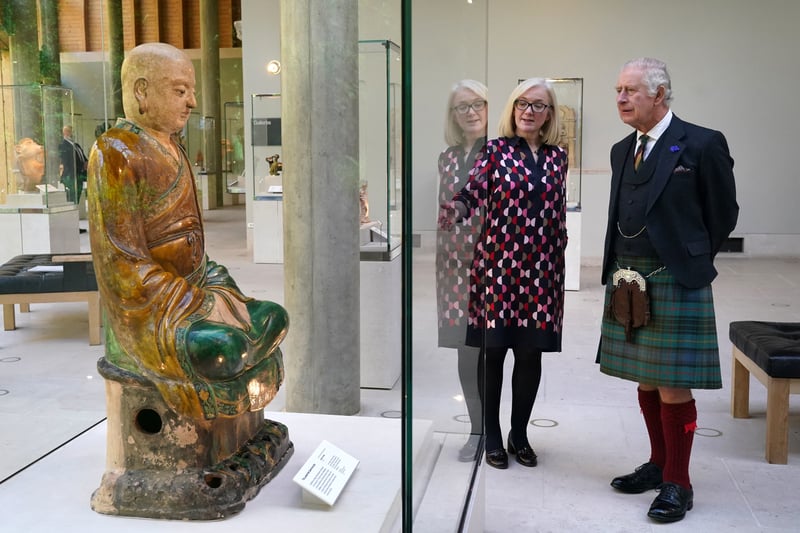 King Charles III alongside senior museum manager Jane Rowlands as they view the figure of a Luohan during a visit to the Burrell Collection to officially re-open it following its six-year long refurbishment, at Pollok Country Park. 