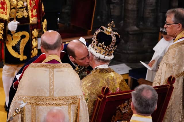 The Prince of Wales kisses his father King Charles III during his coronation ceremony in Westminster Abbey,