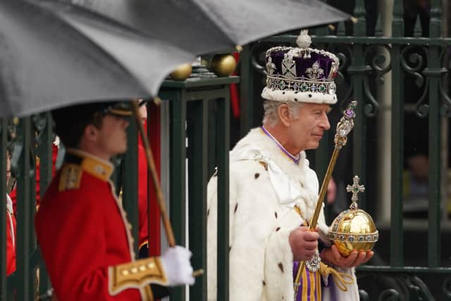 King Charles III, wearing the Imperial State Crown, leaves Westminster Abbey in central London following his coronation ceremony