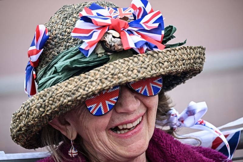 A royal fan wearing a hat covered with Union Jack themed items waits on The Mall. (Photo by LOIC VENANCE/AFP via Getty Images)