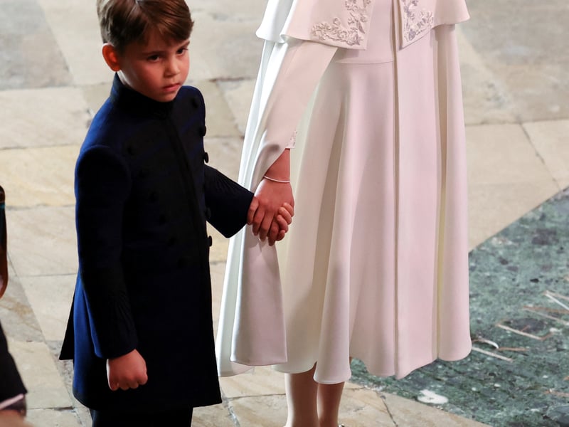 Princess Charlotte holding the hand of her younger brother, Prince Louis