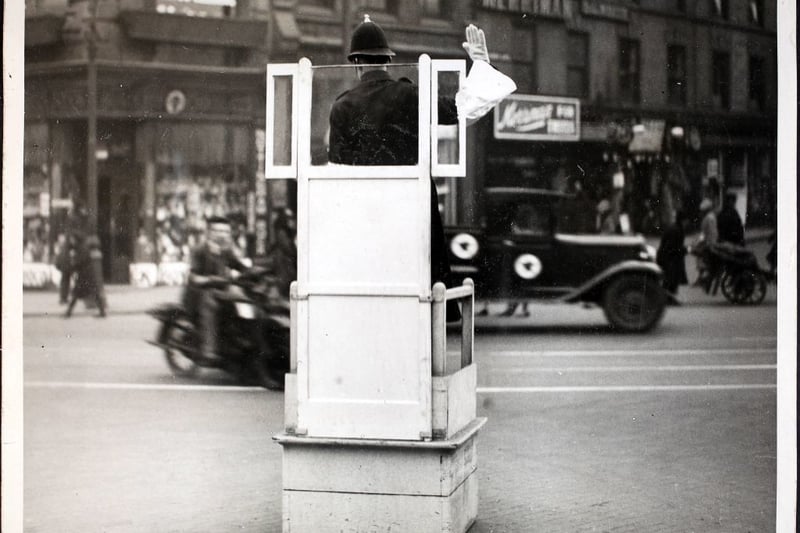 A Nottingham policeman directing traffic from his protected 'pulpit', England, 2nd March 1932