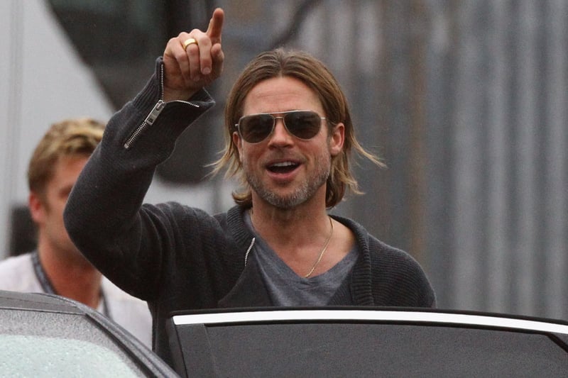 Brad Pitt waves to the crowd after he is spotted leaving a now defunct Kwik Save supermarket in Cardonald. 