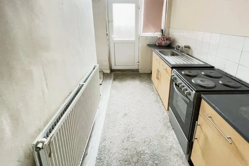 The kitchen is on the smaller side but has access to a back garden area 