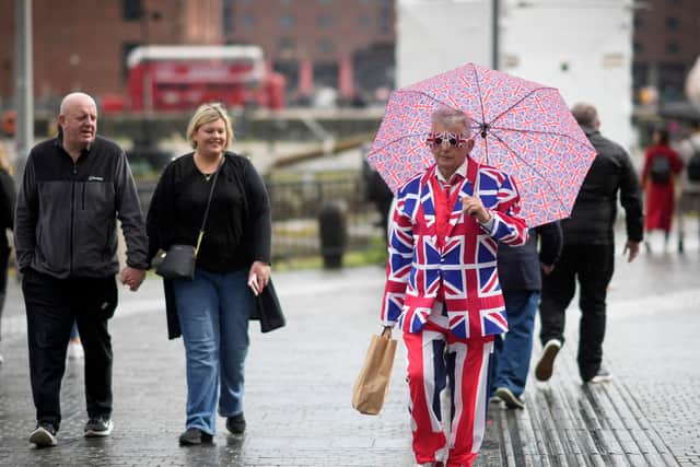 Eurovision fans brave a rain storm as they gather in the fan village.