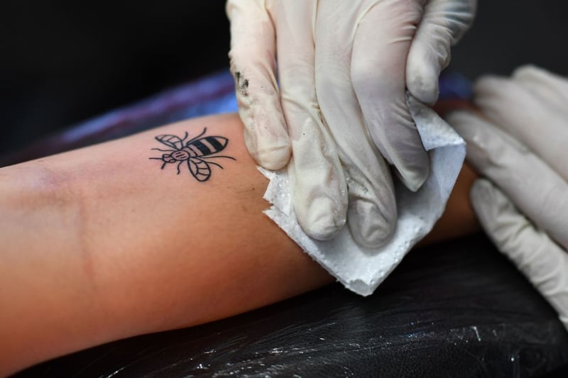 The symbolic worker bee can be seen on every street corner in Manchester and is a symbol of the city’s industriousness. There was a boom in Manchester bee tattoos in 2017 following the arena attack. Tattoo studios across the city were offering discounted Manchester bee tattoos as part of a fundraiser for the victims and their families. (Photo:  BEN STANSALL/AFP via Getty Images)