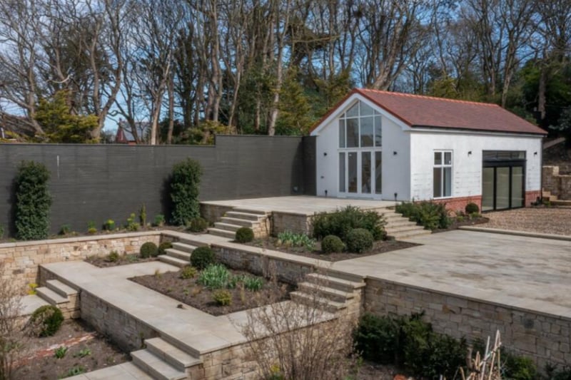 Outside is a beautiful landscaped garden and outbuilding.
