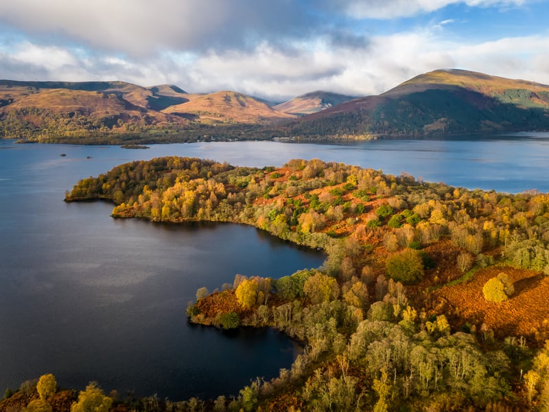 The island is surrounded by a backdrop of spectacular mountain ranges