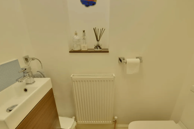 This standard room with a sink and toilet is located underneath the staircase