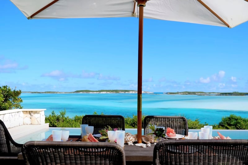 An outside table by a swimming pool on Little Pipe Cay Island