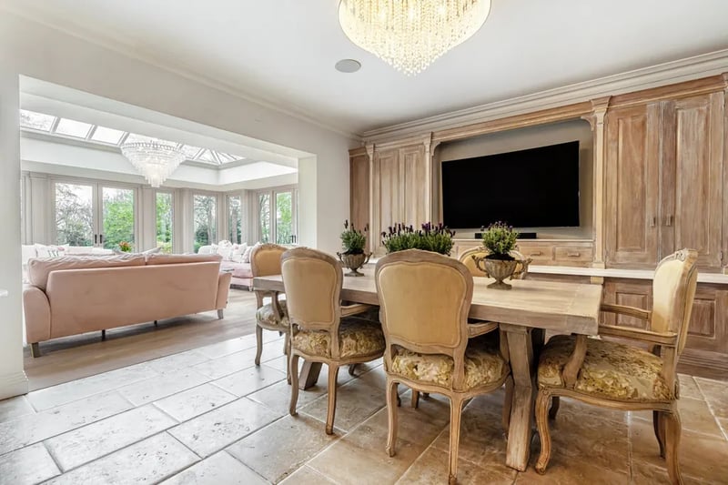 “The breakfast room with its wall of bespoke cabinetry opens up into the fabulous garden room. finished with twin sets of French doors opening into the garden, a huge ceiling lantern and a contemporary “Dru” gas fire for cosy winter nights.”
