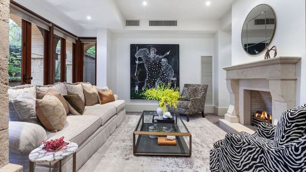 The glamorous Tuscan villa-style dwelling is located in Toorak’s award-winning Villaggio development. The lounge room has an open sandstone fireplace