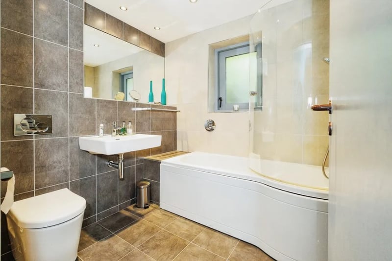 The second bathroom features a large bath with a combined shower