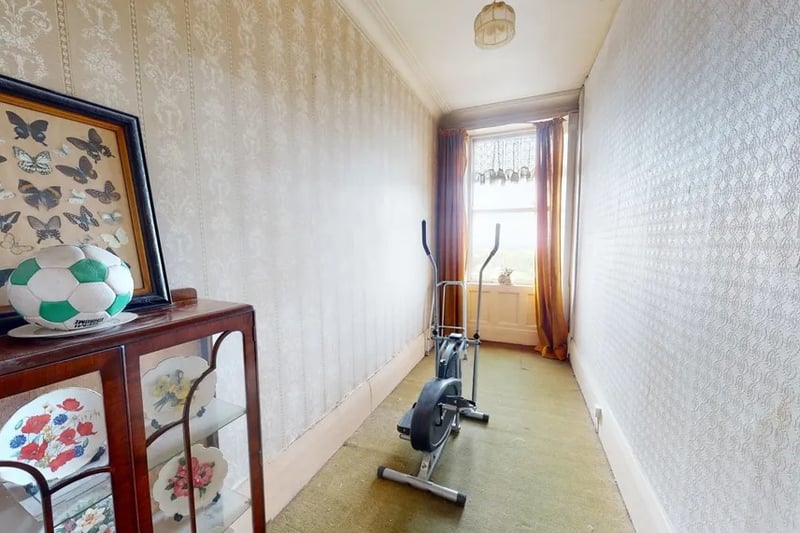 Leading off from the reception room is a smaller room that is currently being used as a workout space