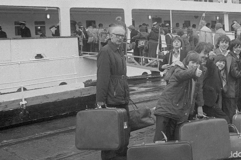 Thumbs-up from the dockside for these children in the queue to board the Uganda in 1977.