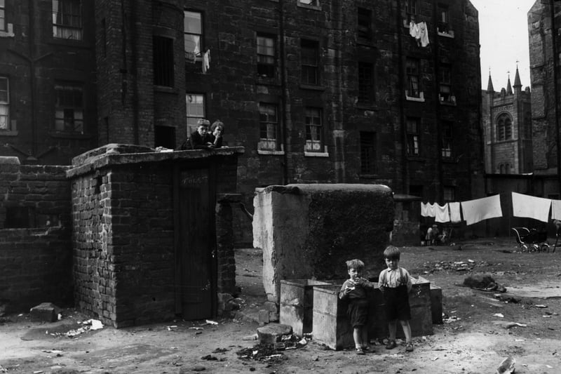 Children playing in a Glasgow slum which is to be demolished. The small building is a lavatory which is shared by eight families. Redevelopment of the area began in the late 1950s and the tenements were replaced with a modern tower block complex in the sixties.  