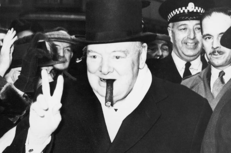 British politician Winston Churchill smoking a cigar and making his famous V sign gesture during an election visit to Glasgow on 18th October 1951. 