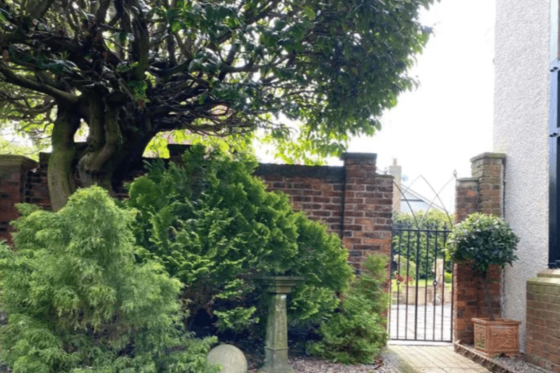 The entrance is emboldened by fascinating trees, hedges and more