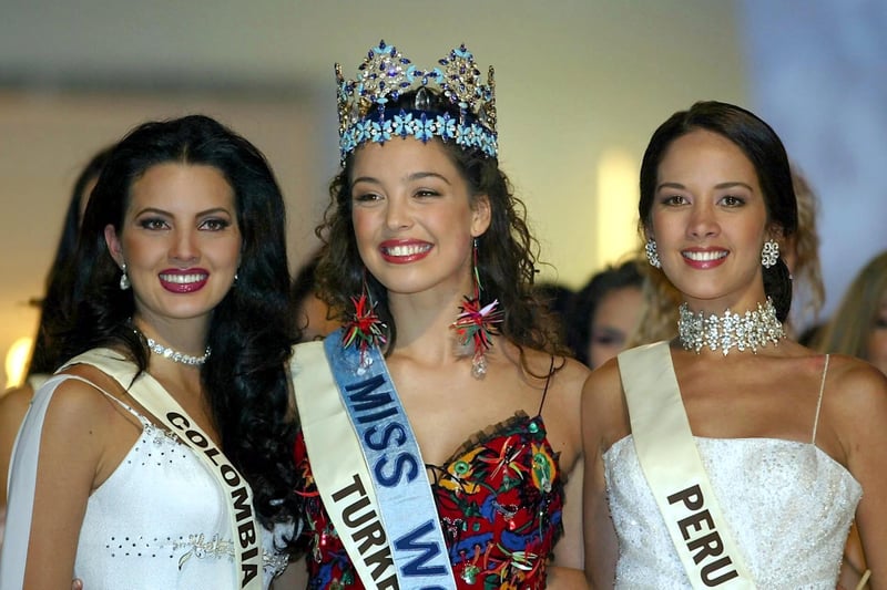 Miss Turkey Azra Akin (c) after being crowned 2002 Miss World with runner-up Miss Columbia Natalia Peralta (l) and third-place Miss Peru Marina Mora Montero.  The event was moved from Nigeria due to riots in the nearby city of Kaduna. Credit: Gerry Penny/AFP via Getty Images.