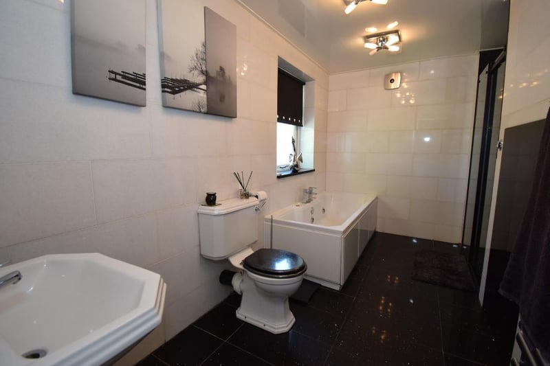 A large family bathroom has a large bath and walk-in shower 