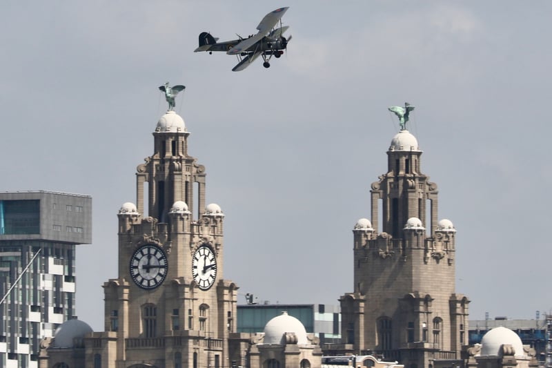 A Swordfish biplane, operated by the Royal Navy prior to and throughout WWII, flies past the Liver Building