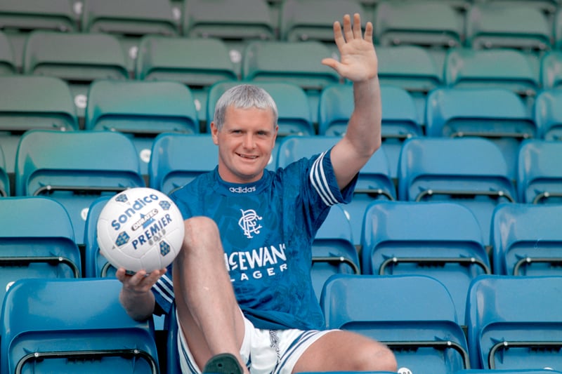 A smiling and waving Paul Gascoigne wears the Rangers adidas home shirt and holds aloft a Sondico match ball after completing his transfer from Italian side Lazio on July 10th, 1995.