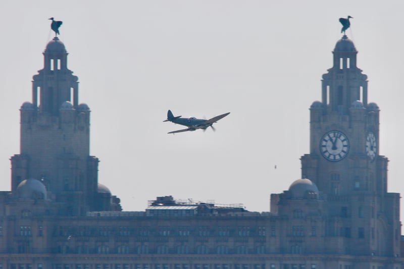 A Spitfire flies past the iconic Liver Building and Bertie and Bella.