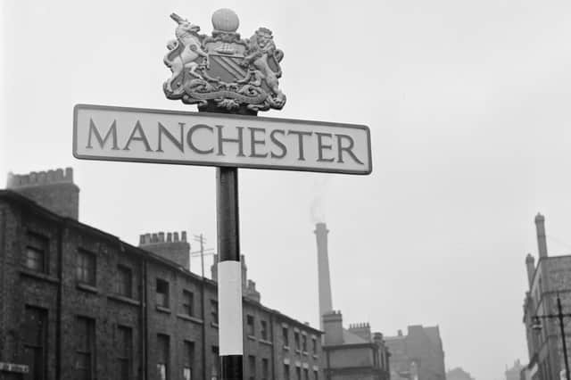 Small textile factories in a street in Manchester, and a road sign with the city's name and crest. circa 1950 (Photo by Three Lions/Getty Images)