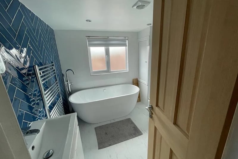 The master suite boasts a beautiful en-suite bathroom, complete with a luxurious freestanding bath and a separate shower. 