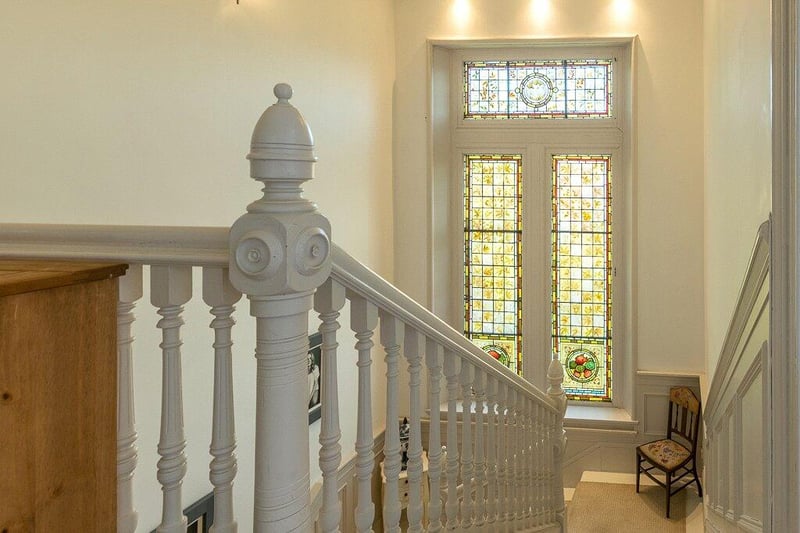 Continuation of grand stairway to upper floor, passing further stunning stained/leaded glass windows. 