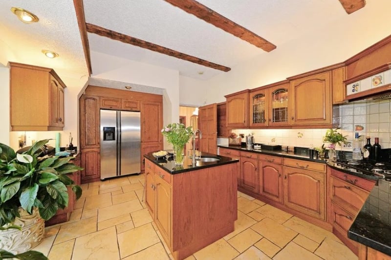 The kitchen has a small island space and also features exposed beams 