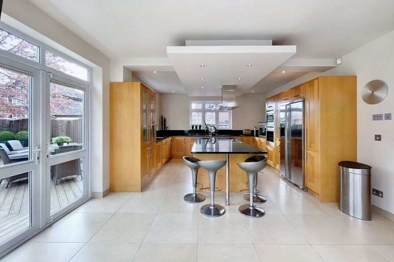 A large open kitchen looks out over the garden and has a big island space for entertaining guests