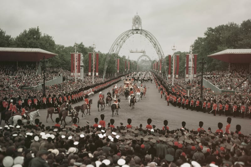 British sailors, soldiers and crowds line the route of Queen Elizabeth's coronation procession, the Mall, London, 2nd June, 1953. Coronation arches can be seen in the background